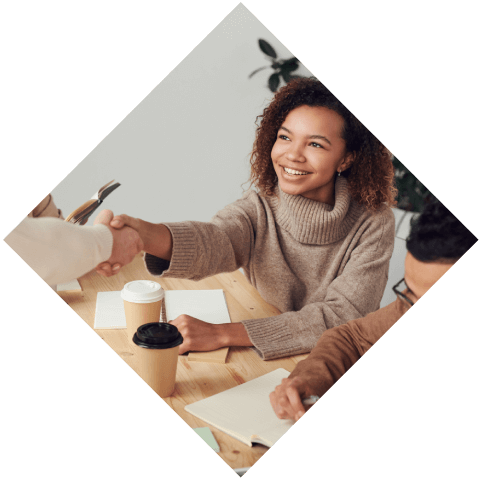 A woman sitting at a table with papers in front of her.